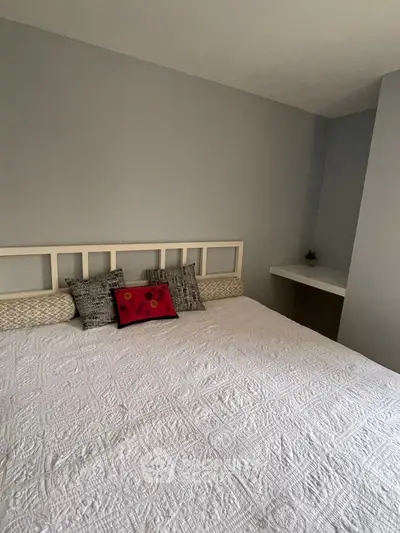 Cozy bedroom with elegant decor and plush bedding in a modern apartment.