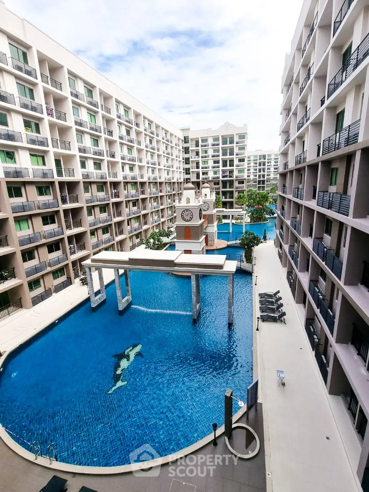 Luxurious condominium complex with stunning pool and modern architecture.