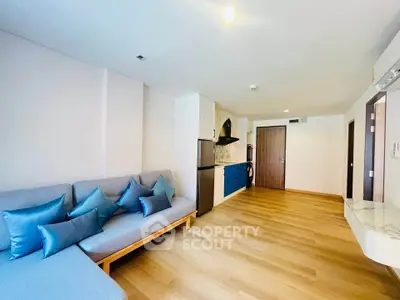 Modern living room with stylish furniture and open kitchen layout in a bright apartment.