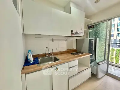 Modern compact kitchen with open layout and balcony view