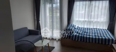 Cozy bedroom with large windows and modern furnishings in a bright apartment.