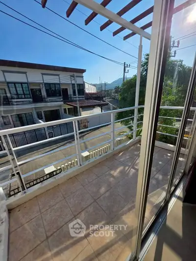 Charming balcony with scenic neighborhood view and ample sunlight, perfect for relaxation.