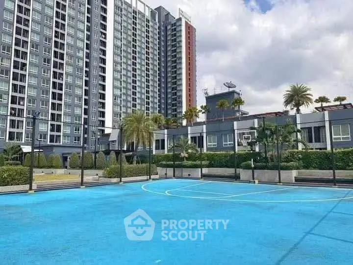 Modern condominium with outdoor sports court and lush landscaping.