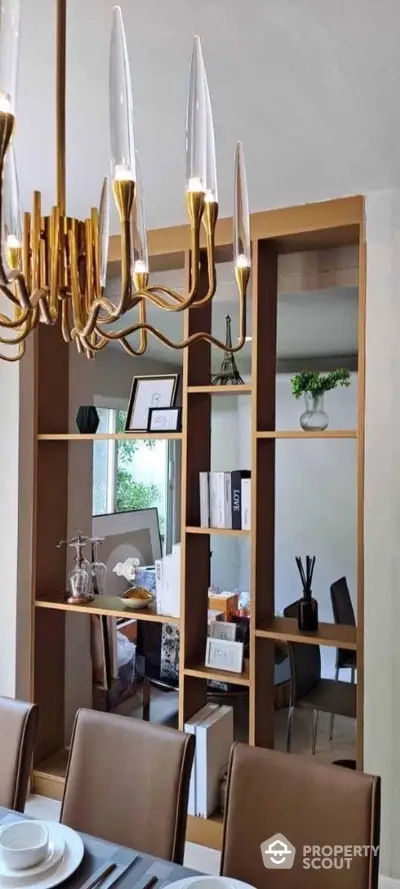 Elegant dining room with modern chandelier and stylish shelving unit