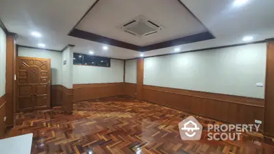 Spacious empty room with wooden flooring and ceiling air conditioning