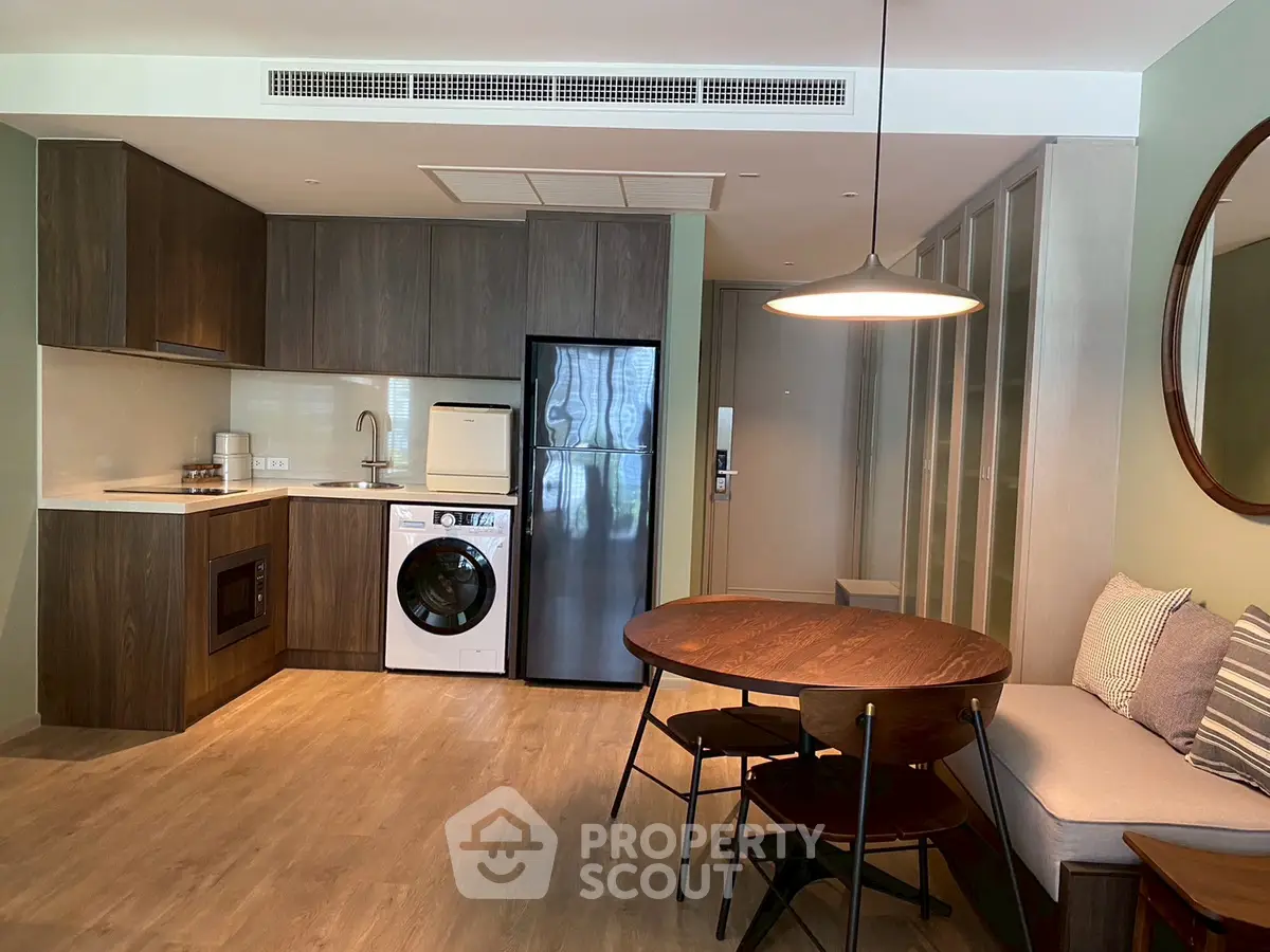 Modern kitchen with open layout, featuring sleek appliances and cozy dining area.