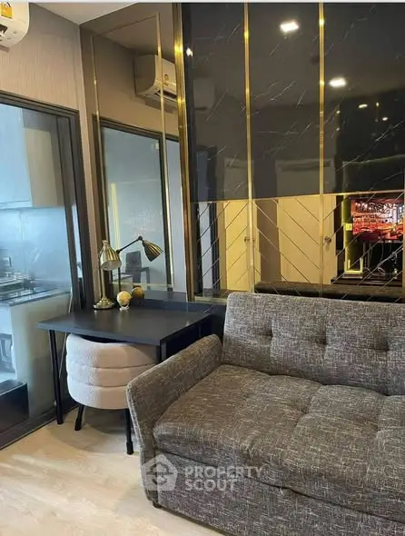 Modern living room with stylish decor and adjacent kitchen area in a contemporary apartment.