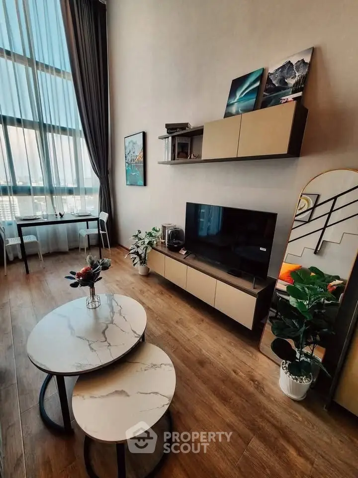 Modern living room with high ceilings, large windows, and stylish decor in a luxury apartment.
