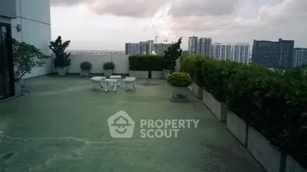 Spacious rooftop terrace with city skyline view and greenery