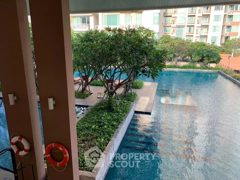 Luxurious apartment complex with stunning pool and lush greenery, perfect for relaxation and leisure.