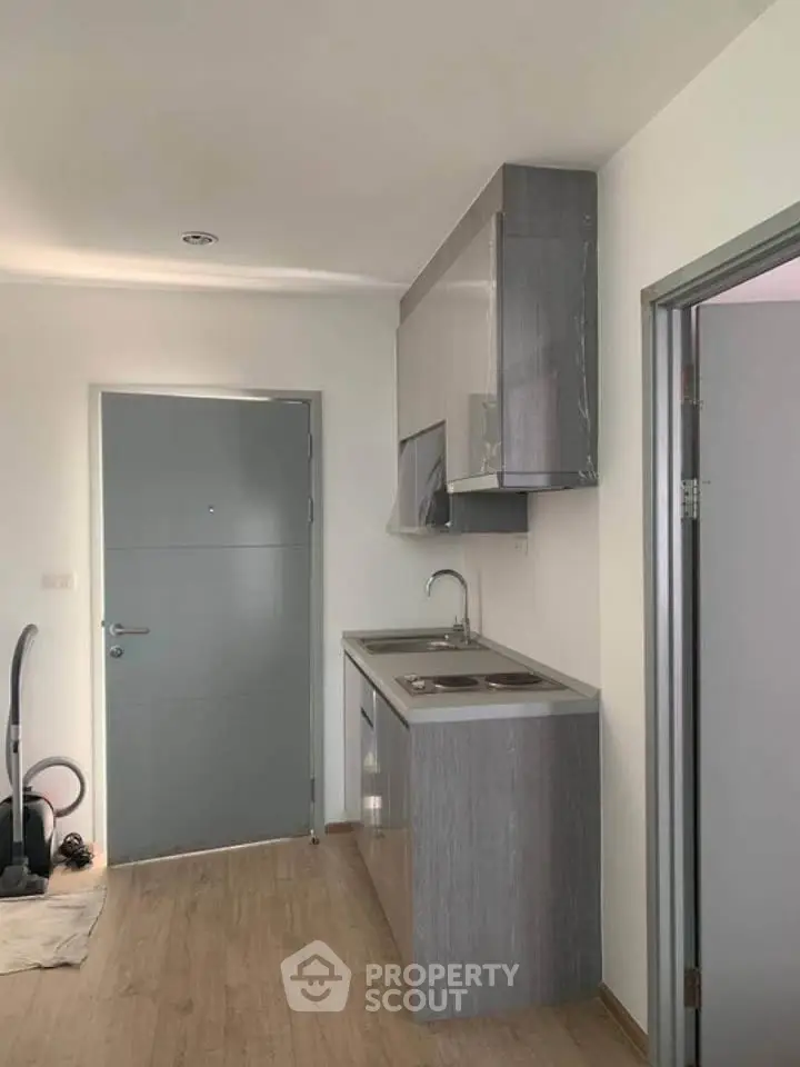 Modern compact kitchen with sleek cabinetry and minimalist design in a contemporary apartment.