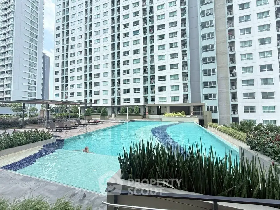 Luxurious high-rise apartment complex with stunning outdoor pool and lush landscaping.