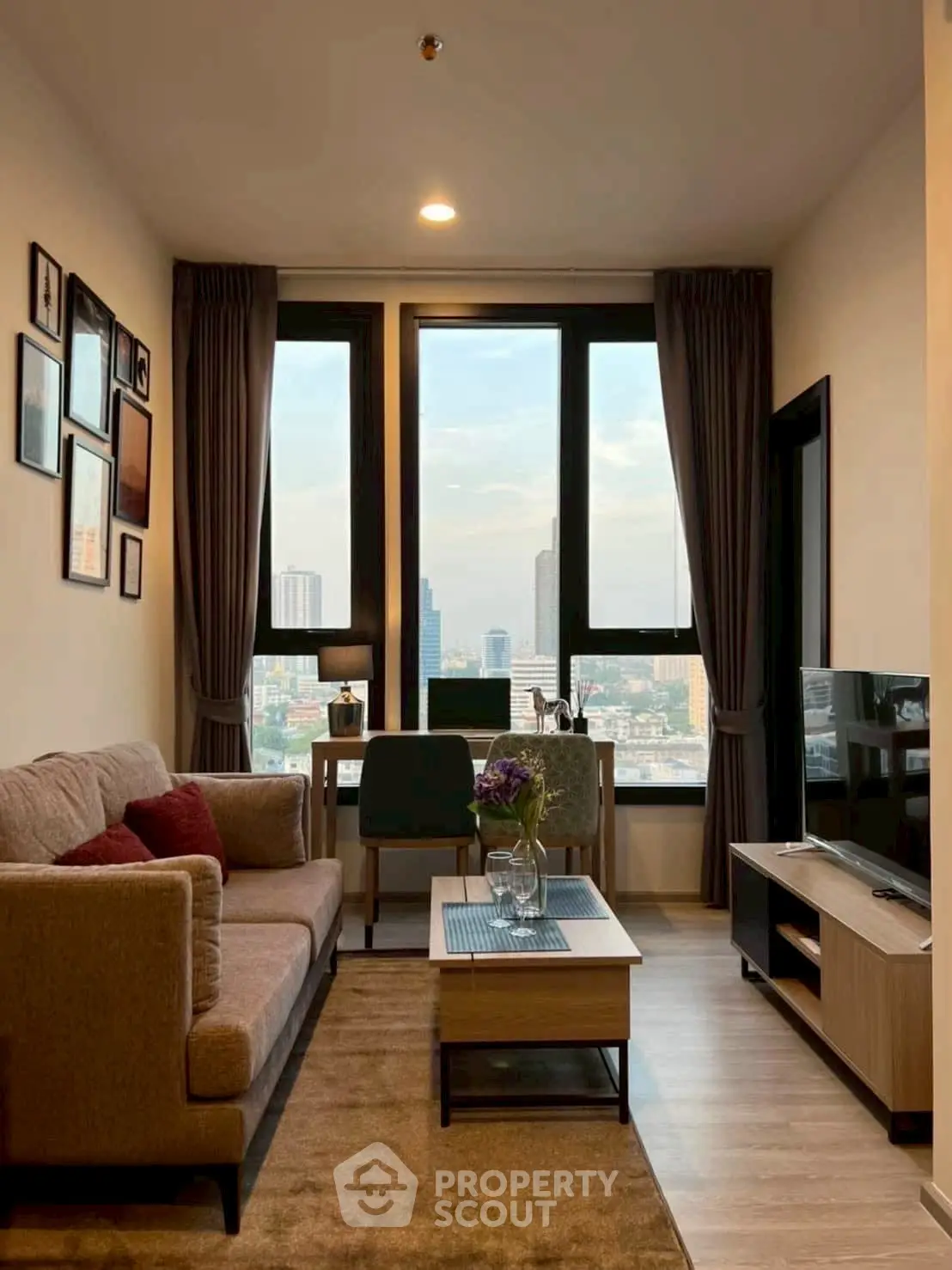Modern living room with city view, cozy sofa, and stylish decor in high-rise apartment.