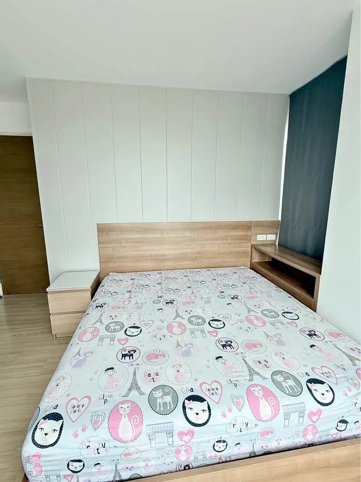 Modern bedroom with stylish wooden furniture and playful bedding in a bright apartment.