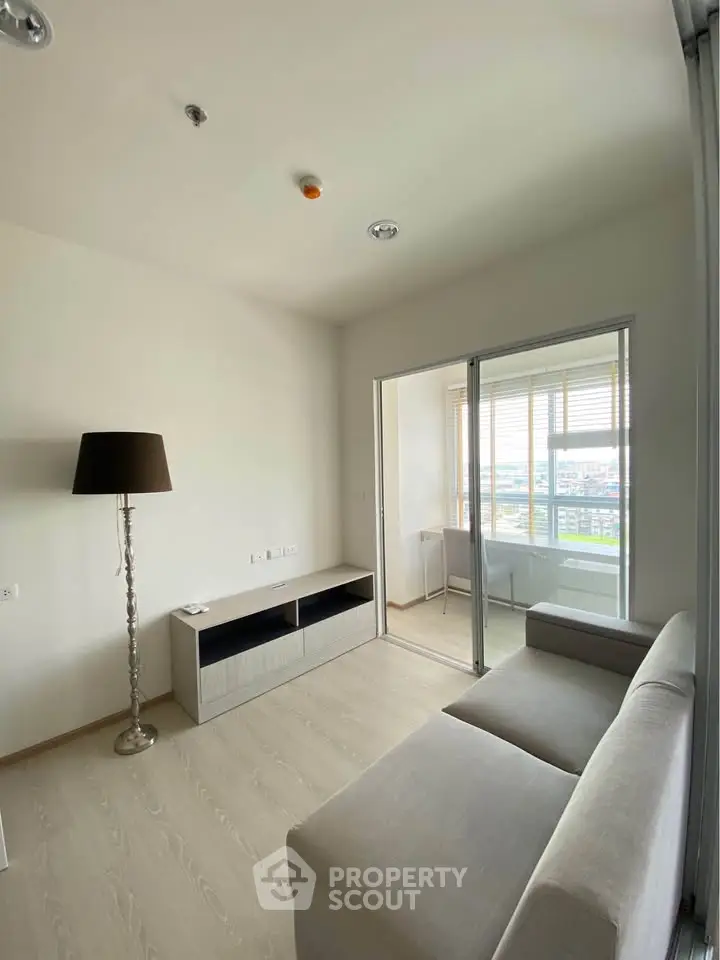 Modern living room with sleek furniture and large windows offering a stunning city view.