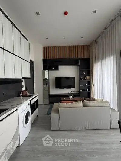 Modern living room with sleek design, featuring a washing machine and stylish furniture.