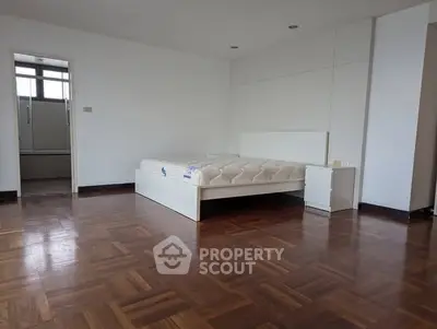 Spacious bedroom with wooden flooring and modern design