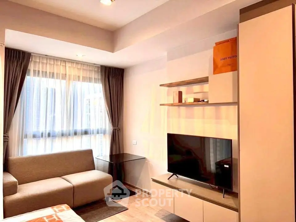 Modern living room with sleek furniture and large window in a stylish apartment.