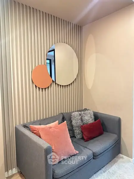 Stylish modern living room with cozy gray sofa and decorative mirrors