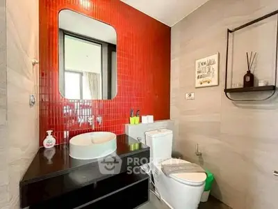 Modern bathroom with red accent wall and sleek fixtures