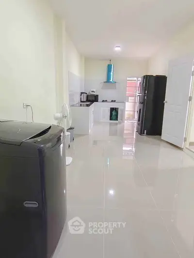 Spacious kitchen with modern appliances and sleek tile flooring in a contemporary home.