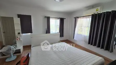 Spacious bedroom with natural light and modern furnishings in a cozy home.