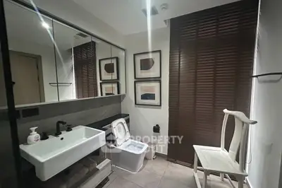 Modern bathroom with sleek design, featuring a stylish sink, contemporary toilet, and elegant decor.