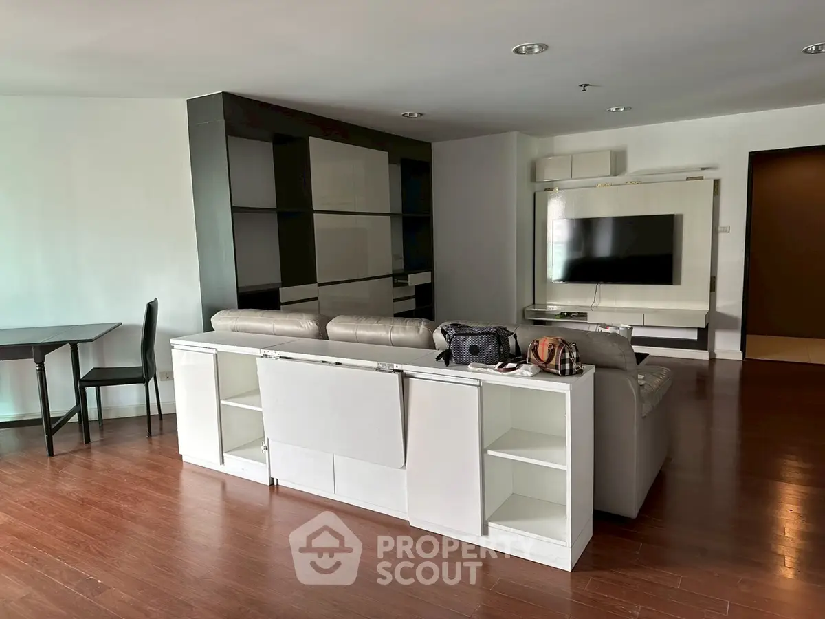 Spacious living room with modern entertainment setup and sleek wooden flooring