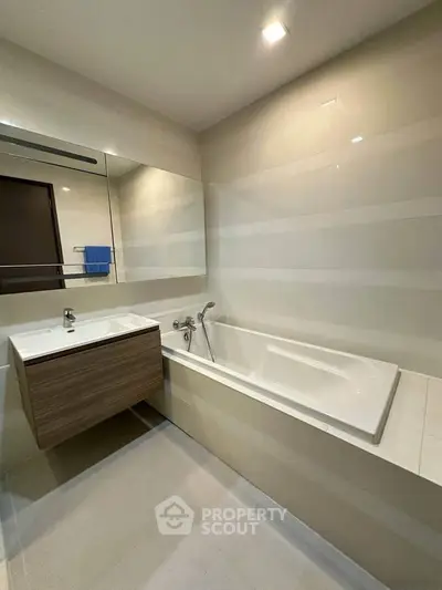 Modern bathroom with sleek design featuring a built-in bathtub and stylish vanity.