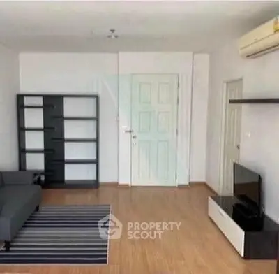 Spacious living room with modern furniture and wooden flooring, perfect for relaxation and entertainment.