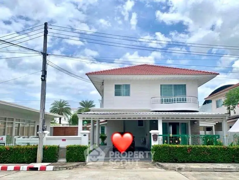 Charming two-story house with red roof and lush greenery in a serene neighborhood.
