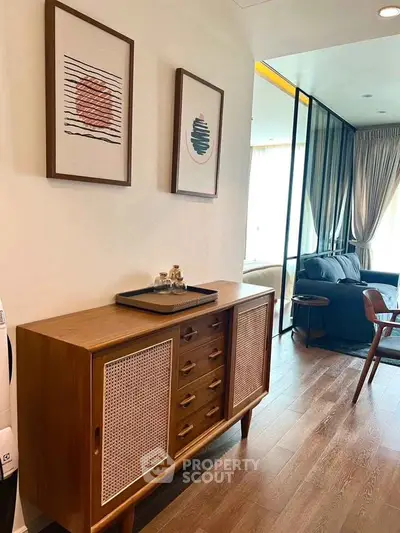 Stylish living room with modern furniture and elegant decor, featuring a wooden sideboard and framed art.