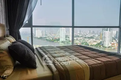 Luxurious bedroom with panoramic city view from floor-to-ceiling windows, featuring elegant bedding and modern decor.
