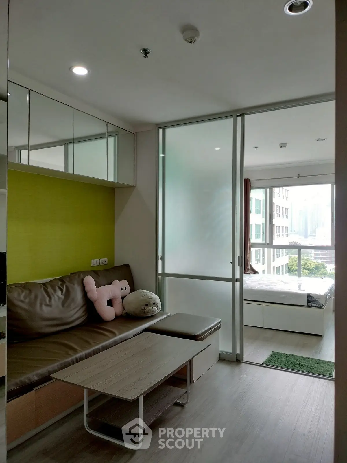 Modern apartment interior with cozy living area and bedroom view, featuring stylish furniture and natural light.