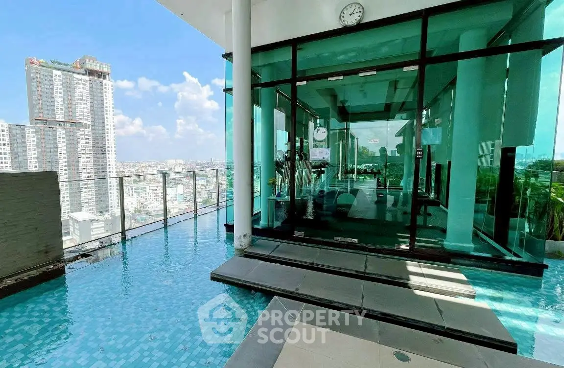 Stunning rooftop pool with panoramic city views and modern glass architecture.