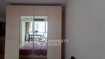 Spacious bedroom with mirrored wardrobe and city view balcony