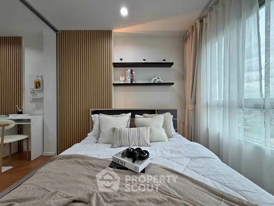 Modern bedroom with cozy decor and natural light, featuring stylish shelving and a comfortable bed.