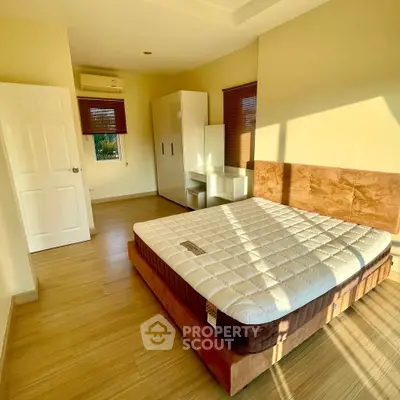 Bright and cozy bedroom with wooden flooring and ample natural light