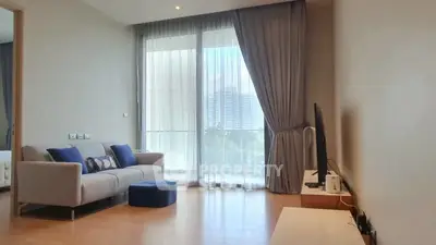 Spacious living room with modern decor and large window offering natural light.