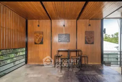 Charming wooden interior with artistic decor and serene garden view, perfect for relaxation and inspiration.