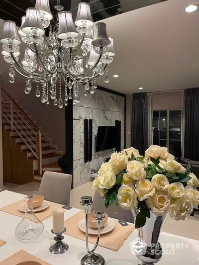 Elegant dining area with chandelier and floral centerpiece in modern home