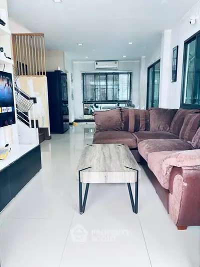 Spacious living room with modern sectional sofa and sleek coffee table, perfect for relaxation and entertainment.