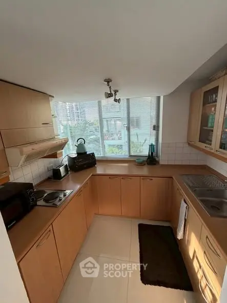 Charming kitchen with wooden cabinetry and natural light, perfect for culinary enthusiasts.