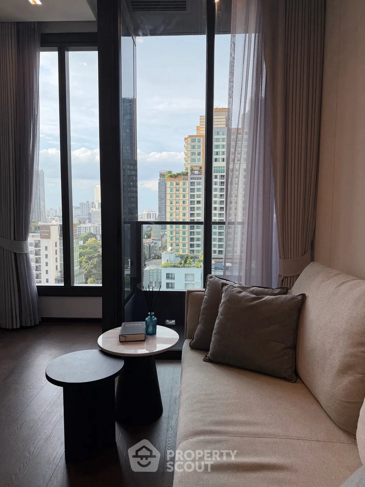 Modern living room with city view, featuring elegant sofa and stylish coffee table.