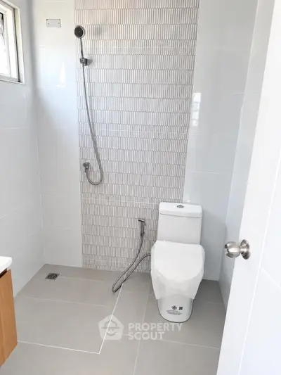Modern bathroom with sleek shower and tiled walls in a contemporary home.