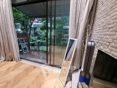 Stylish living room with sliding glass doors opening to a lush garden view.