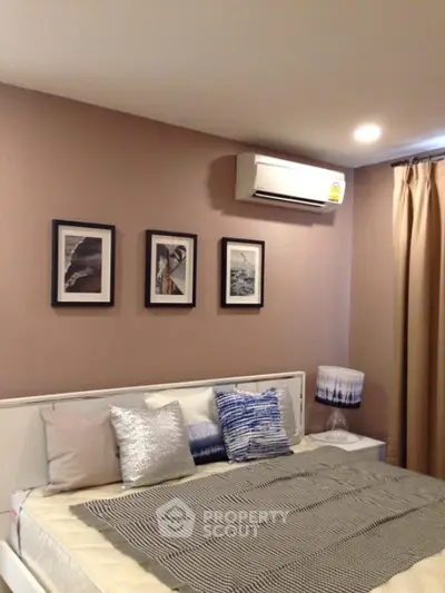 Cozy bedroom with modern decor and air conditioning, perfect for relaxation.