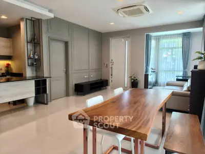 Modern open-plan living and dining area with sleek wooden table and stylish decor