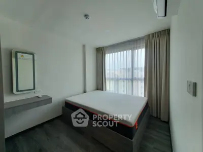 Modern minimalist bedroom with large window and sleek furnishings