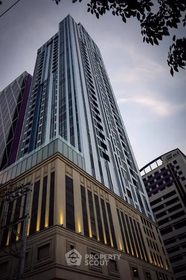 Stunning modern high-rise building with unique architectural design and elegant facade lighting.